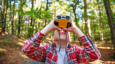a child looking up at the sky/trees through goggles