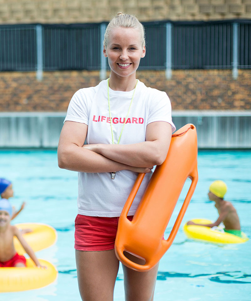 a lifequard taking a picture near a pool