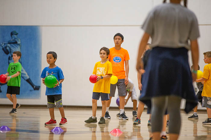 kids and teens at the YMCA gym playing dodgeball