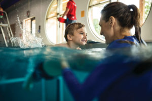 boy at swim lesson in water with instructor