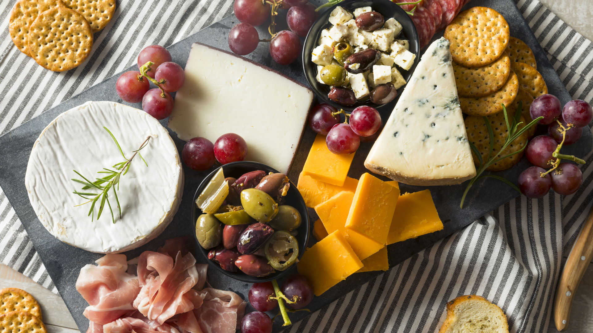 platter of cheeses, grapes and olives