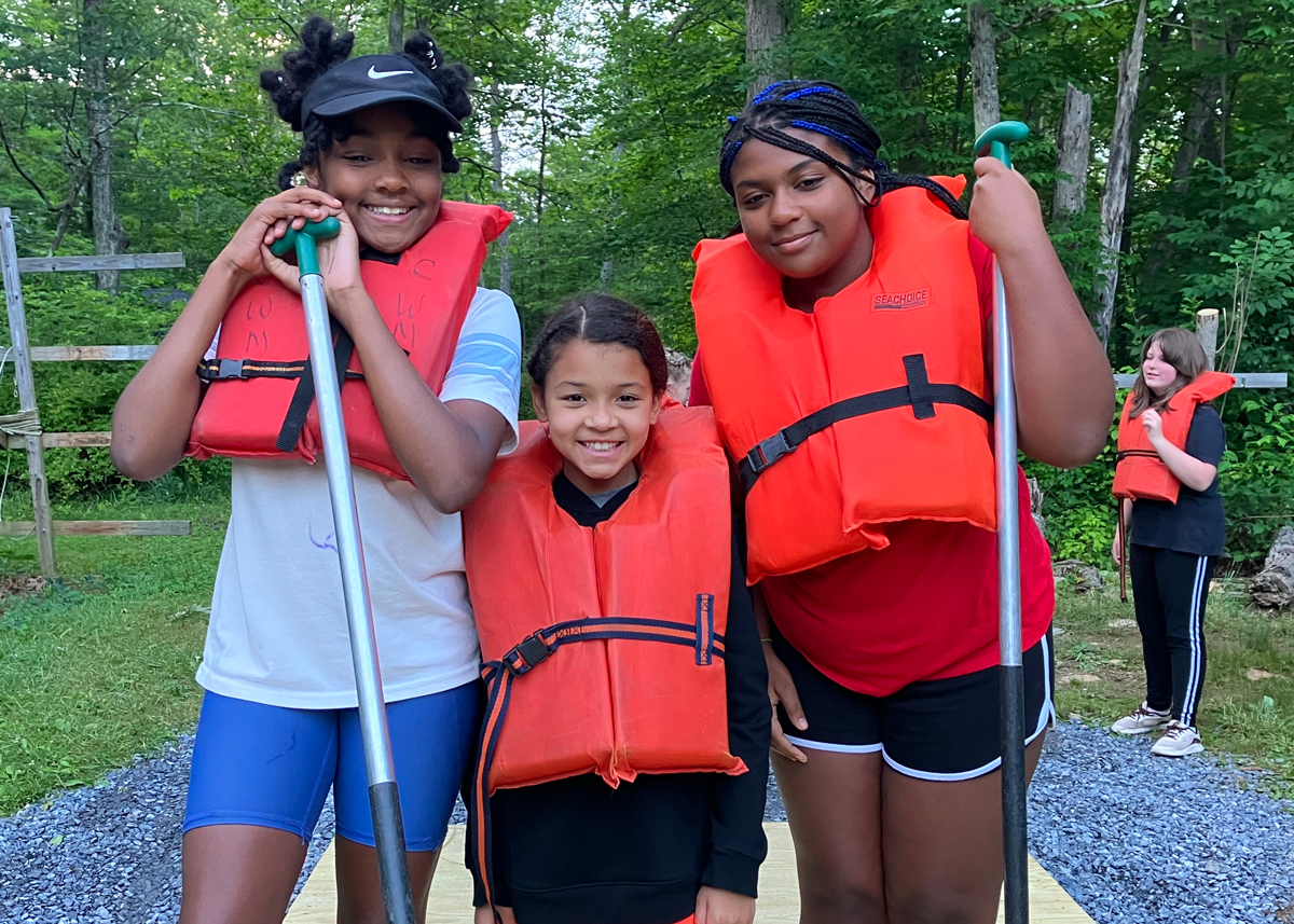 Summer campers canoe with life jackets